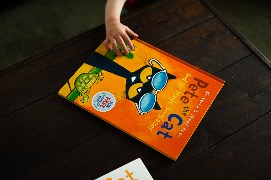 child's hand reaching for Pete the Cat book