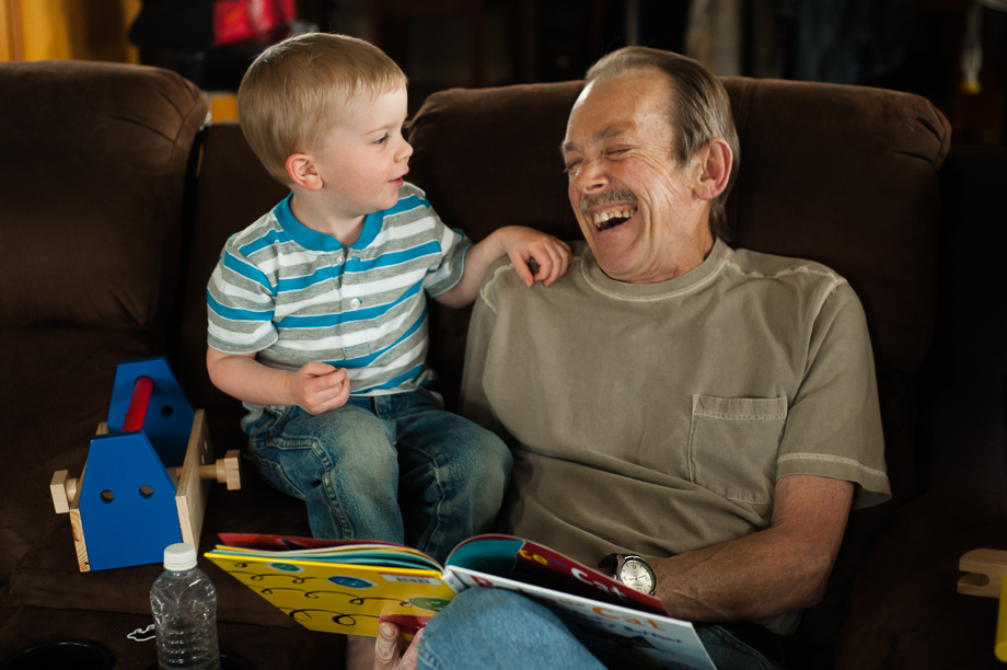 man and boy laughing over book
