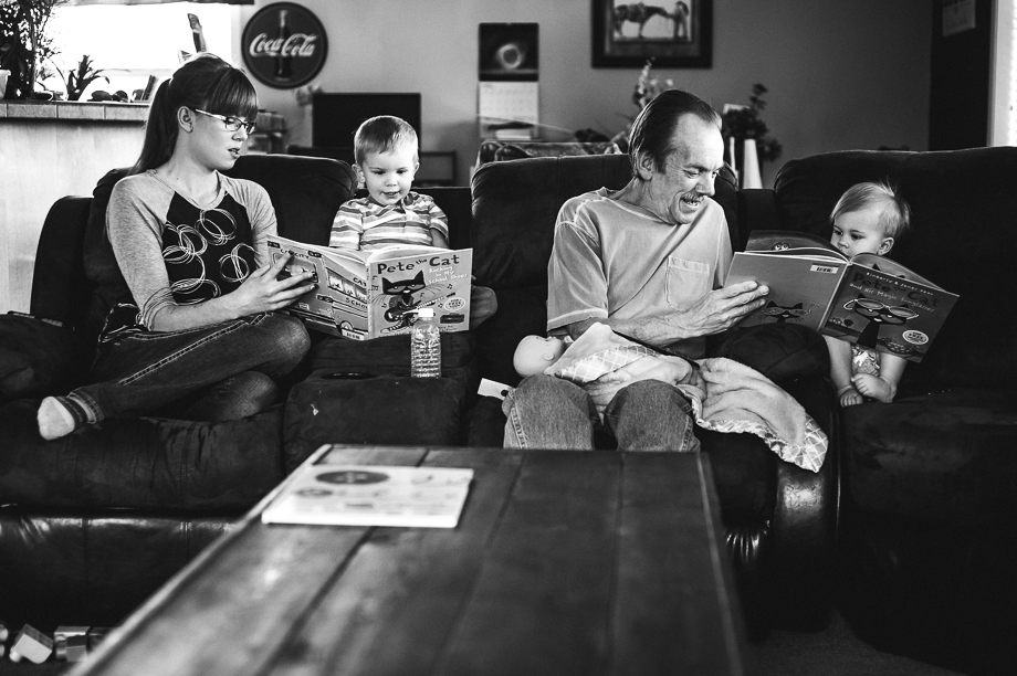 family reading book on couch
