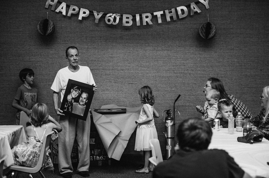 emotional dad holding photo at birthday party