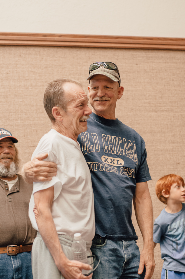 smiling older men friends embrace