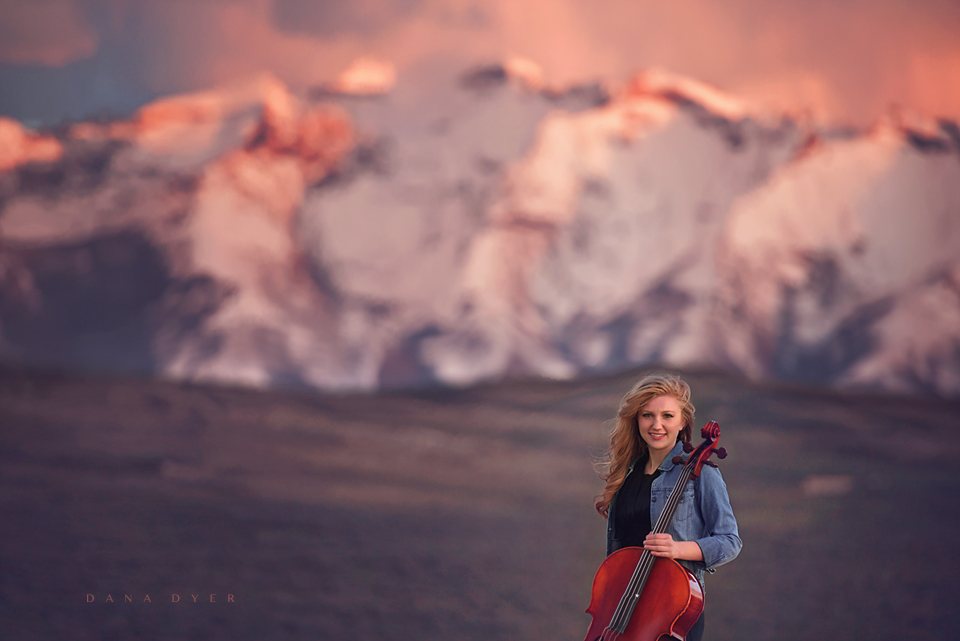girl on mountain range with cello