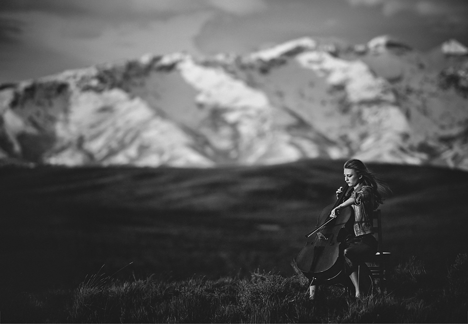 woman playing cello by mountain
