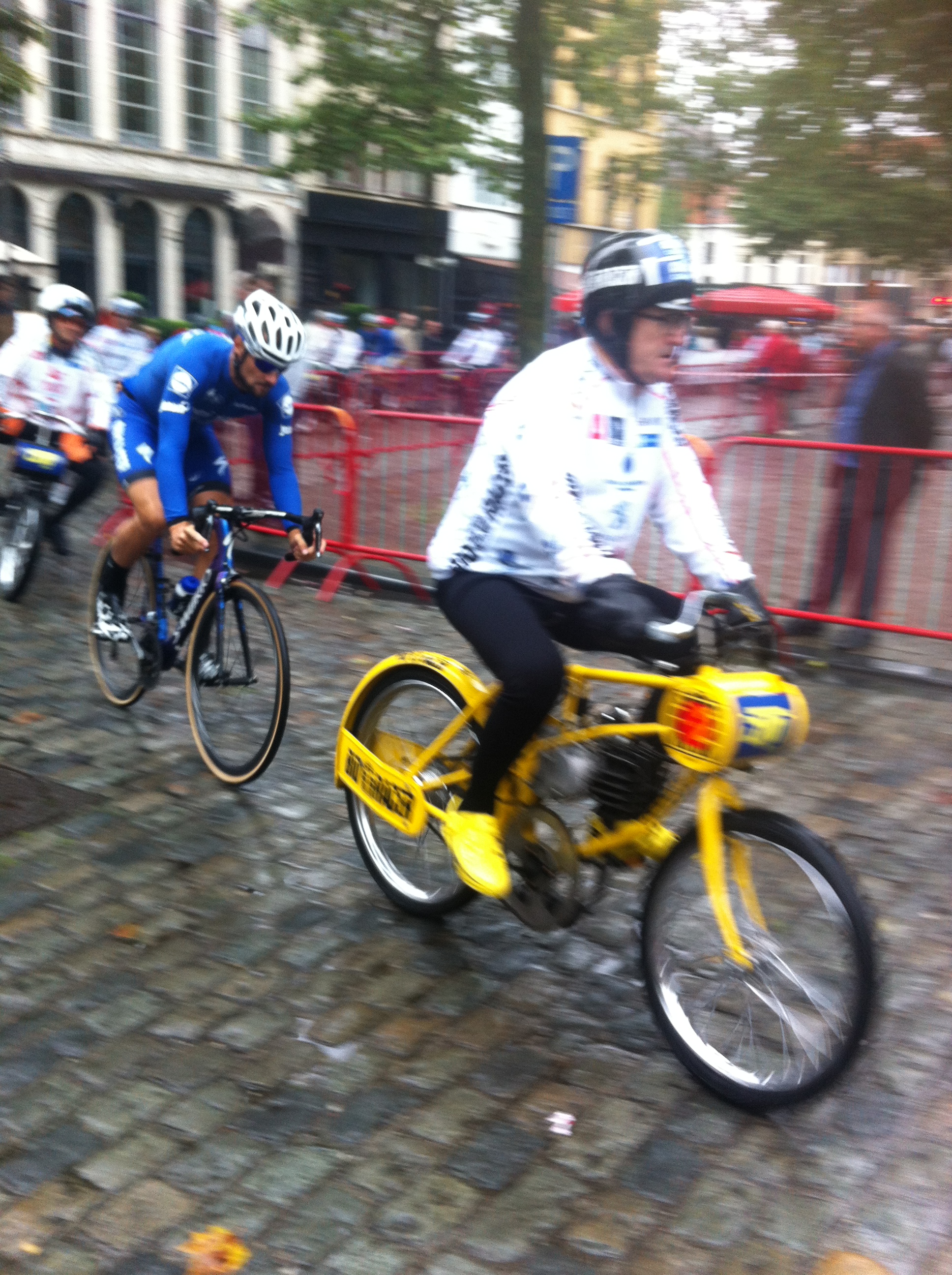 Tom Boonen takes the left hand turn across the greasy cobbles in steady rain at the Antwerp Derny Classic. The derny riders themselves are usually ex professionals with excellent bike handling skills. They also have strict dress codes as to what they can wear (obviously more is better to assist the rider for less wind resistance). To get around the dress code restrictions the "naturally bigger" the derny rider the better. 