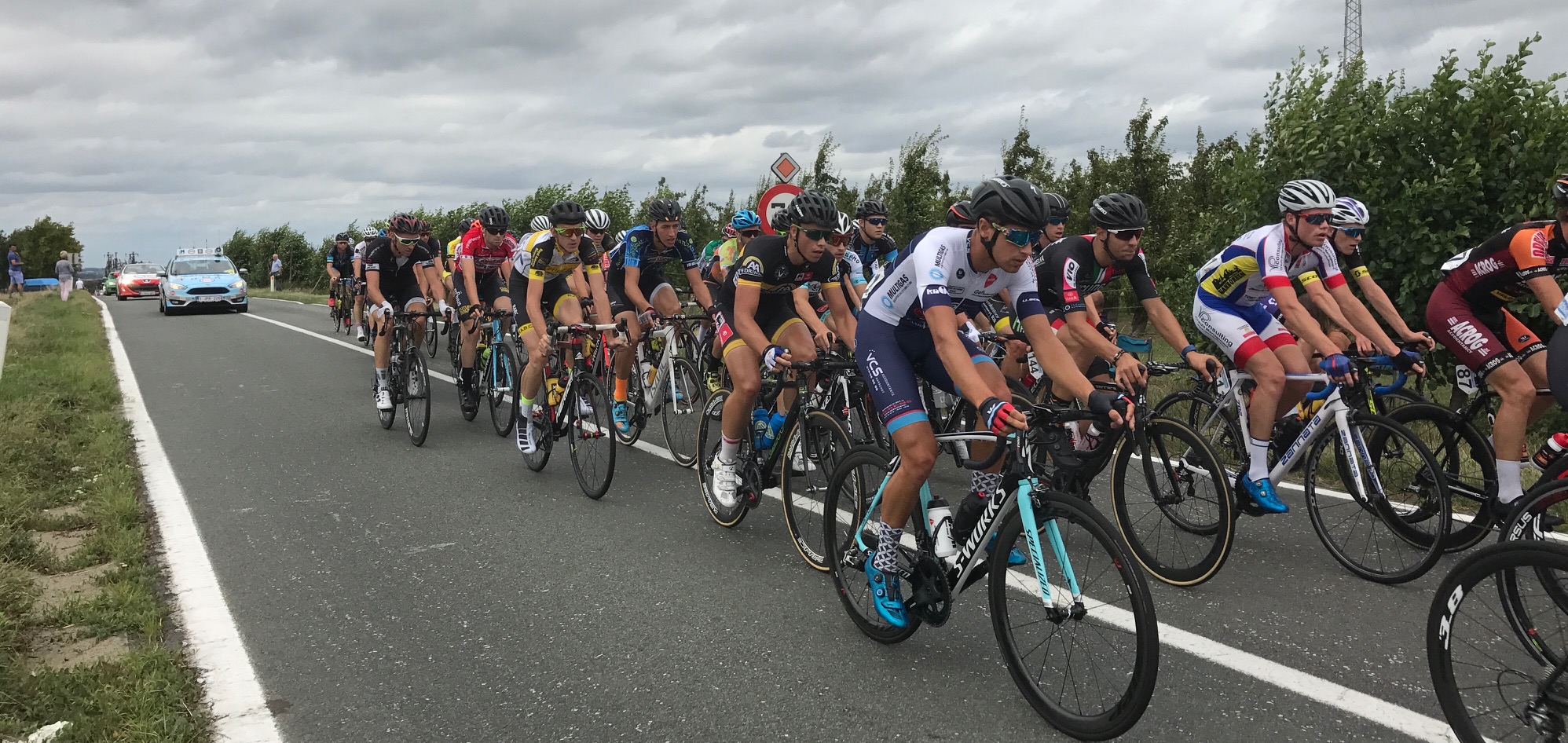 Brabant 17 (Stage 4) - the peloton goes over the top of the Landenberg climb in heavy crosswinds (Peter in red on left of shot). The peloton split & then reformed numerous times in what was a gruelling day. Peter finished 113th on the stage @ 6min 10 seconds. 