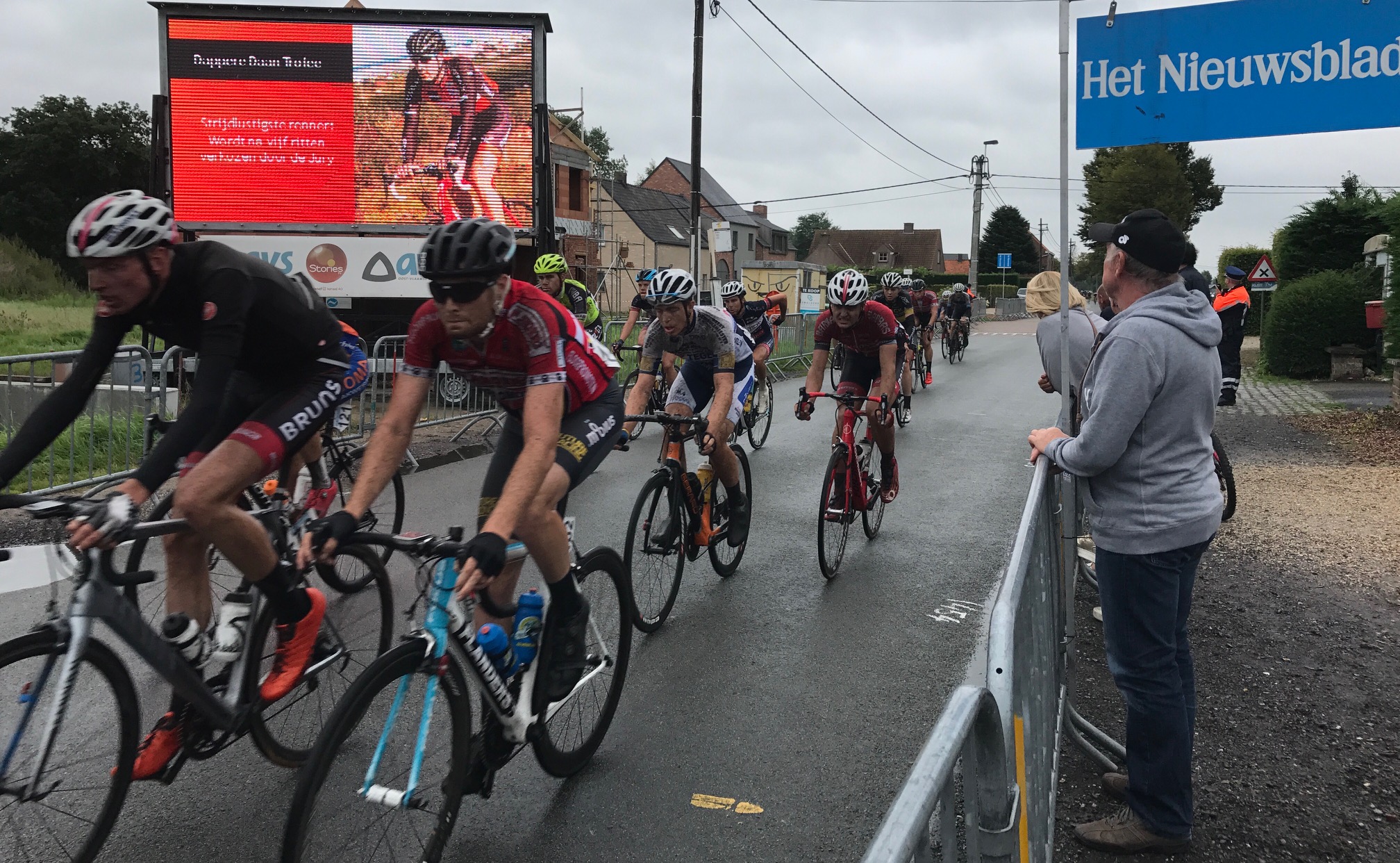 Tour of East Flanders 17 Stage 2 - Peter passes through the finishing straight on lap 3 at Adegem with the rain coming down. The course was generally on narrow one lane paths around the outskirts of the Ursel Air Force Base. Conditions were simply awful being greasy, dangerous & wet which guaranteed numerous crashes with the roads literally awash with cow shit (it was everywhere). Peter was another excellent peloton finish just 19 seconds behind the breakaway winner for 74th. The Flanders team lost another rider retired today & another was lucky (?) to be classified as a finisher (not sure how the Commissaires reach that decision when the rider most certainly pulled out with over 20k to go). The Flanders team would start Stage 3 with just three riders and 16 riders retired on the stage today. The Belgian support team of Eddy Verbust & Freddy Verleyem (in grey jacket above) came to see Peter in the difficult conditions. 