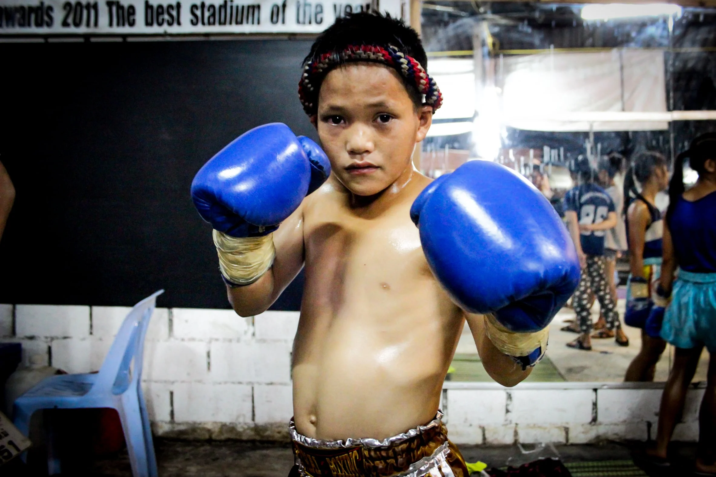  Many children are recruited to start practicing Muay Thai from as young as seven years old. As trainers, spectators and gamblers watch, they fight to win glory for their gym and prize money. For many children and their families, Muay Thai is often seen as an escape from poverty. Chiang Mai, Thailand.