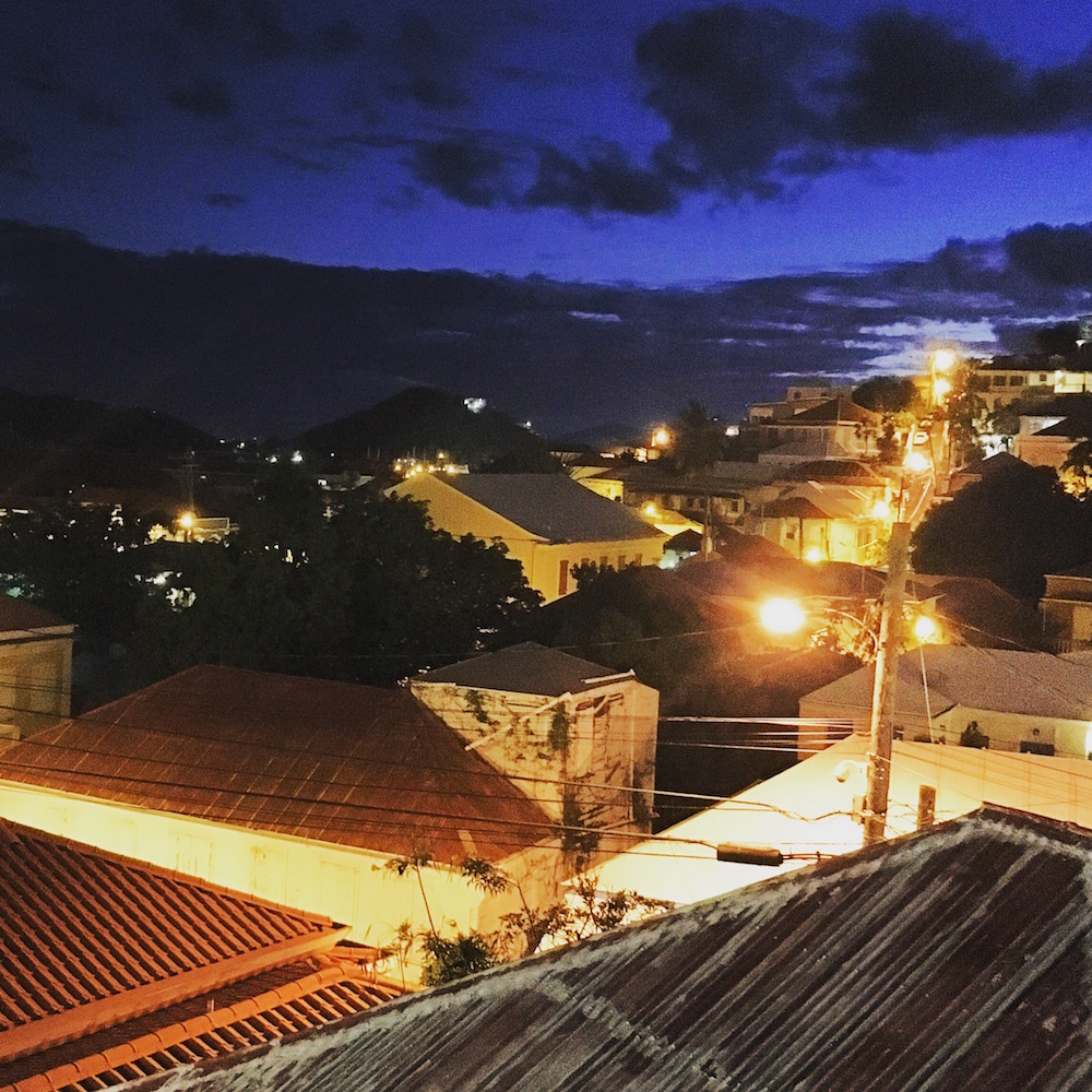 The Sugarcane Grille overlooks a courtyard with a small pool in one direction, and this charming cityscape where dusk hangs beautifully in the sky as street lambs climb the hill.
