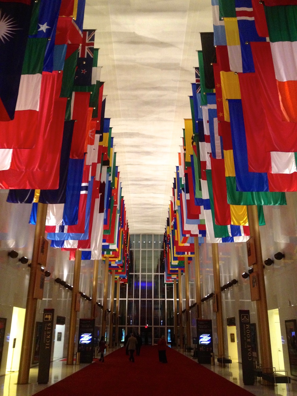 E Pluribus Unum . Out of many, one. The flags of the many places we've come from -- the world's vibrant nations -- hang majestically at the Kennedy Center in Washington, DC.