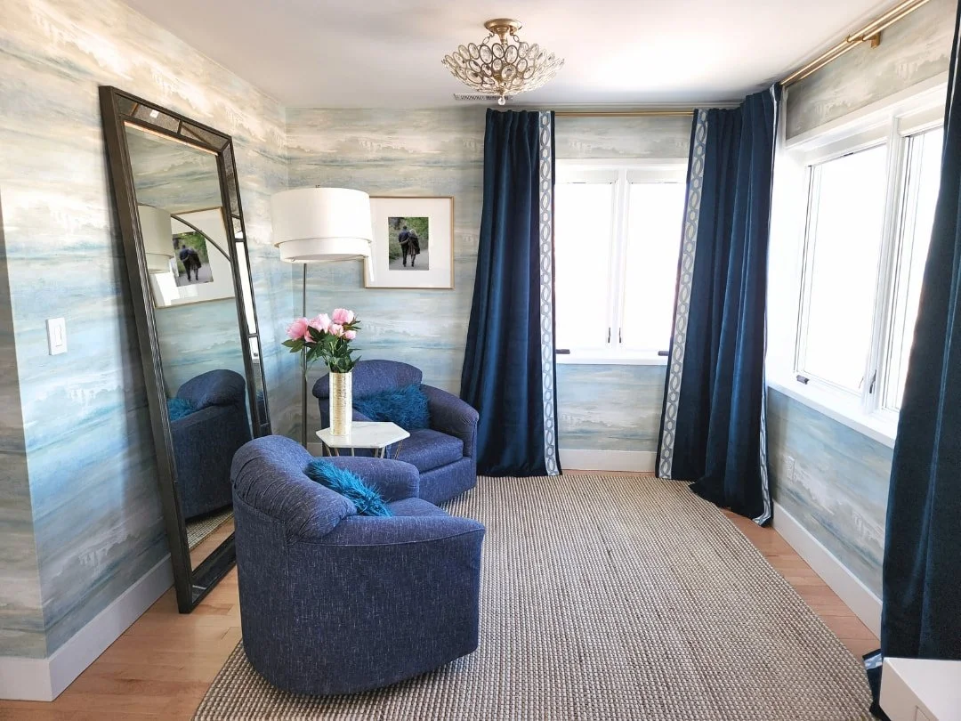 Modern transitional coastal bedroom design featuring serene wallpaper blue chairs and curtains
