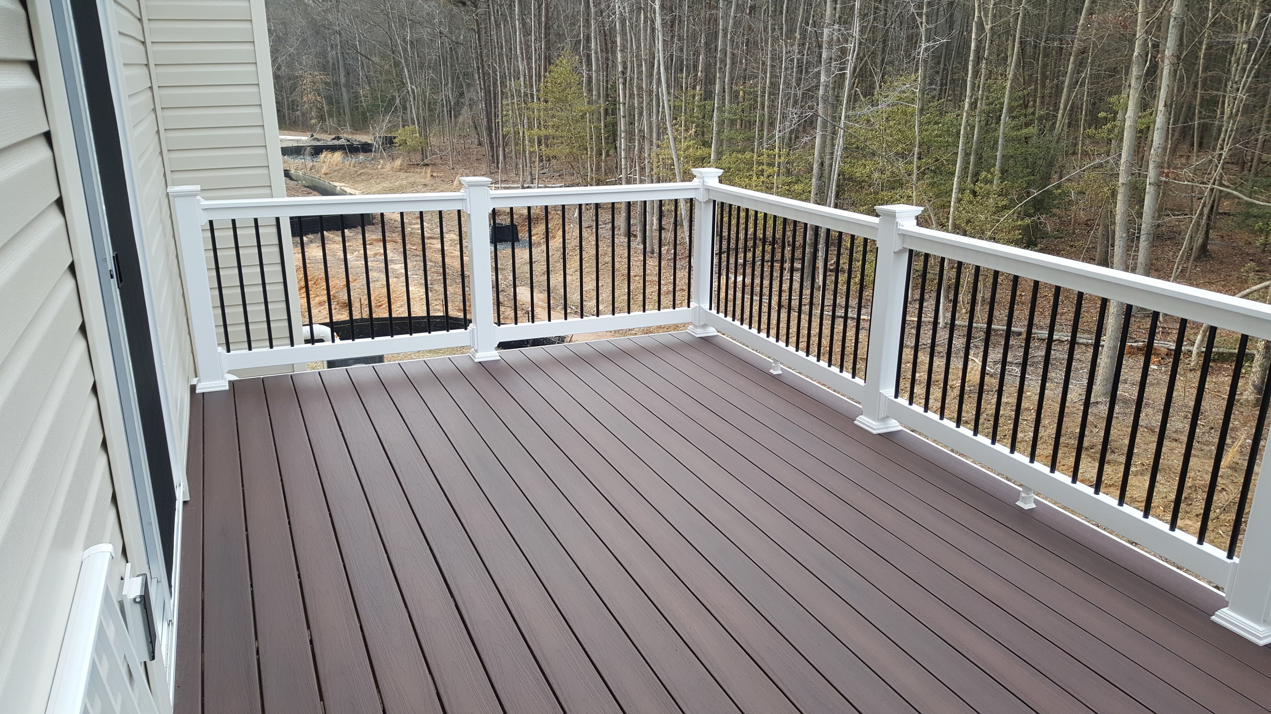 Fiberon rosewood decking, monument rails with black aluminum balusters. Tiger claw hidden fasteners.