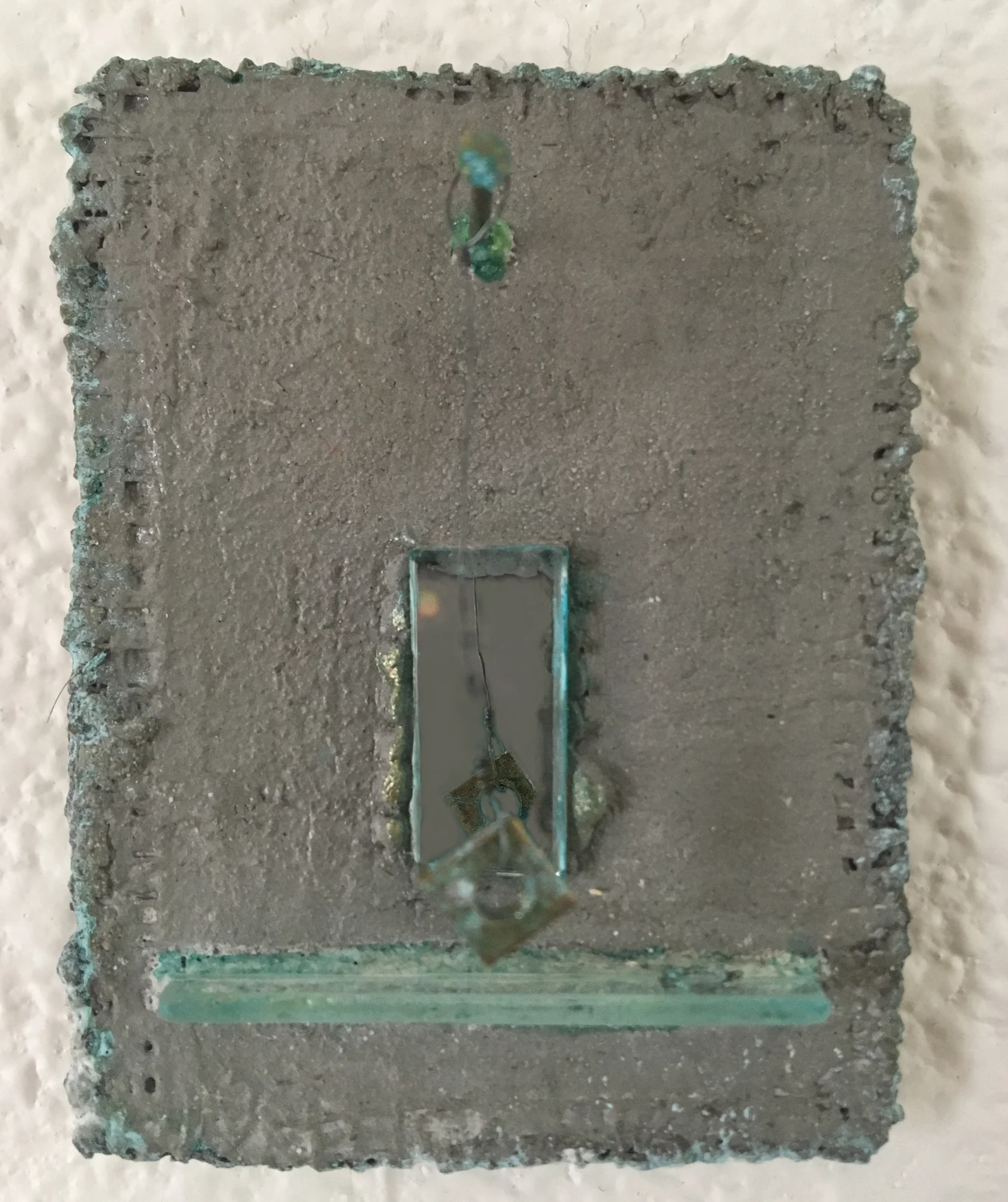  Pendulum ( sold )  Found objects, glass, and pigment on hand formed cement panel  3 inches high x 2 inches wide  (those aren’t typos—some of these are tiny) 