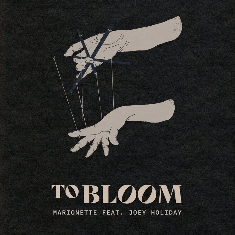 Illustration of two hands controlling puppet strings, with the text "TO BLOOM" and "Marionette feat. Joey Holiday" below.