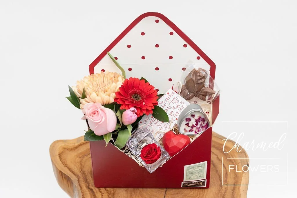 The  Love Letter Bundle Deluxe filled with flowers, chocolates, lip balm, and candle. The perfect Valentines day gift!