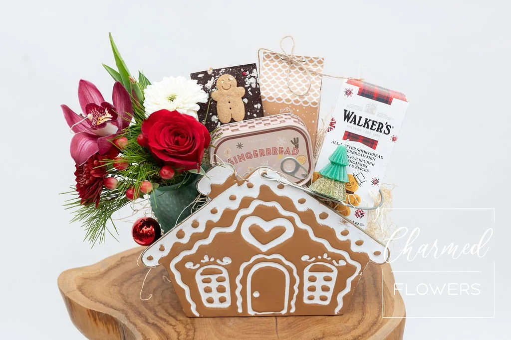 A holiday themed gift basket including holiday arrangement  A soy Gingerbread Candle  Gingerbread cookies  Chocolate  A small tree candle  Truffles all wraped up in a gingerbread basket