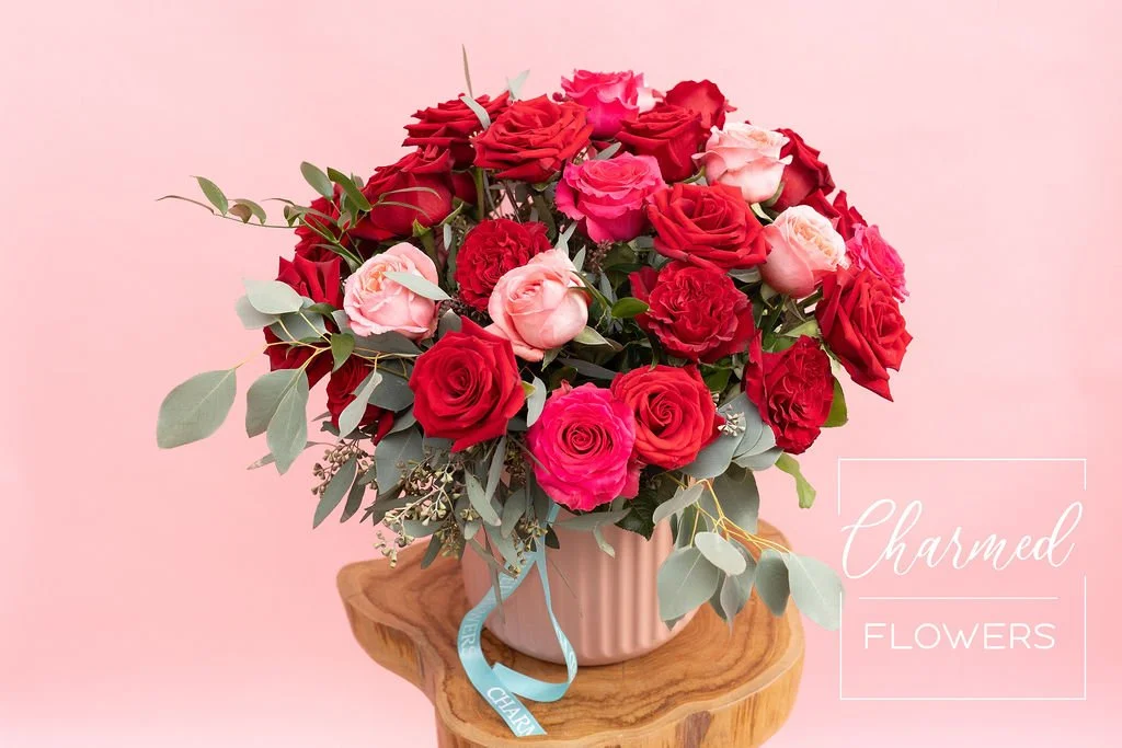 Rose Romance is a show stopping rose arrangment of a variety of pink and red roses arranged in a big beautiful pink vase
