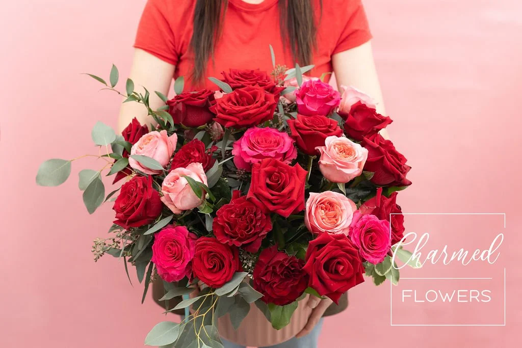 Rose Romance is a show stopping rose arrangment of a variety of pink and red roses arranged in a big beautiful pink vase