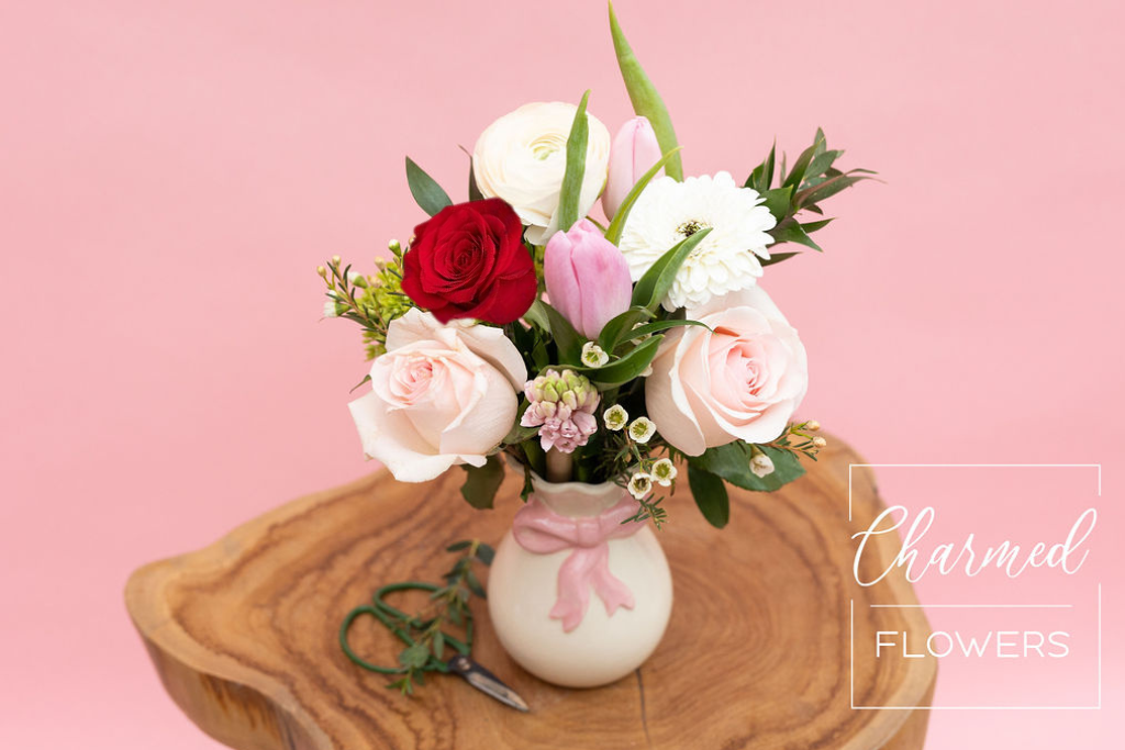 The Be Mine vase arrangment is a petite style with pinks and a hint of red. The charming vase has a pink bow design.
