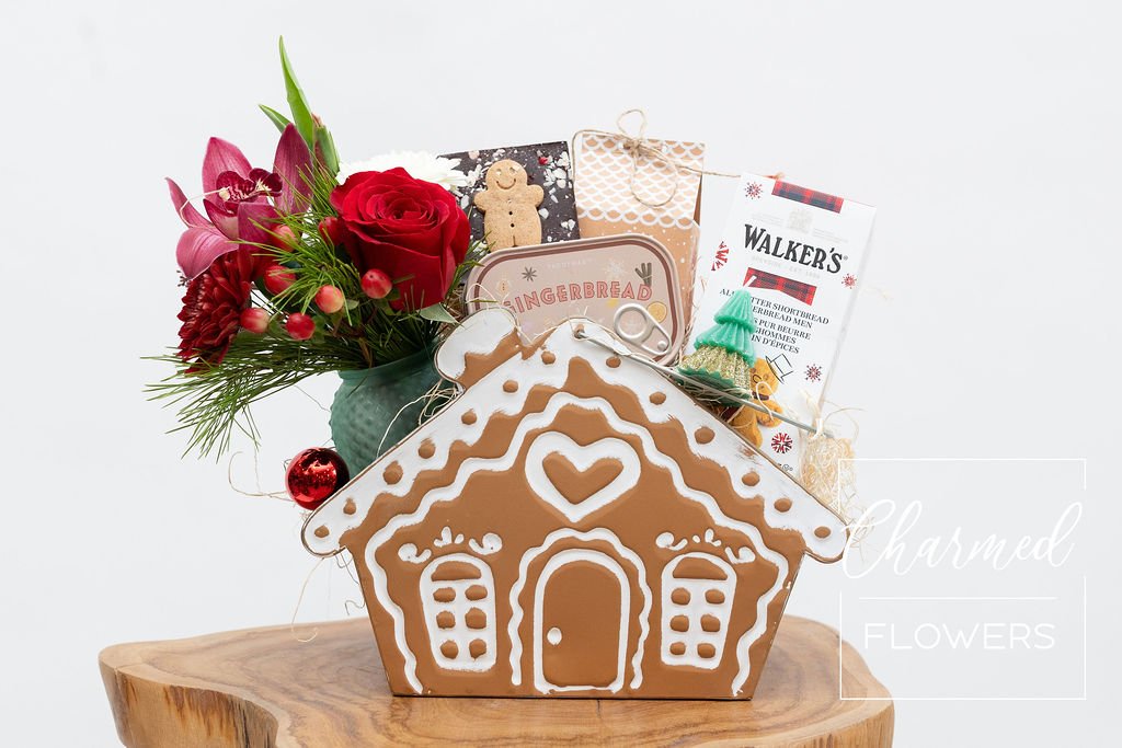 A holiday themed gift basket including holiday arrangement  A soy Gingerbread Candle  Gingerbread cookies  Chocolate  A small tree candle  Truffles all wraped up in a gingerbread basket