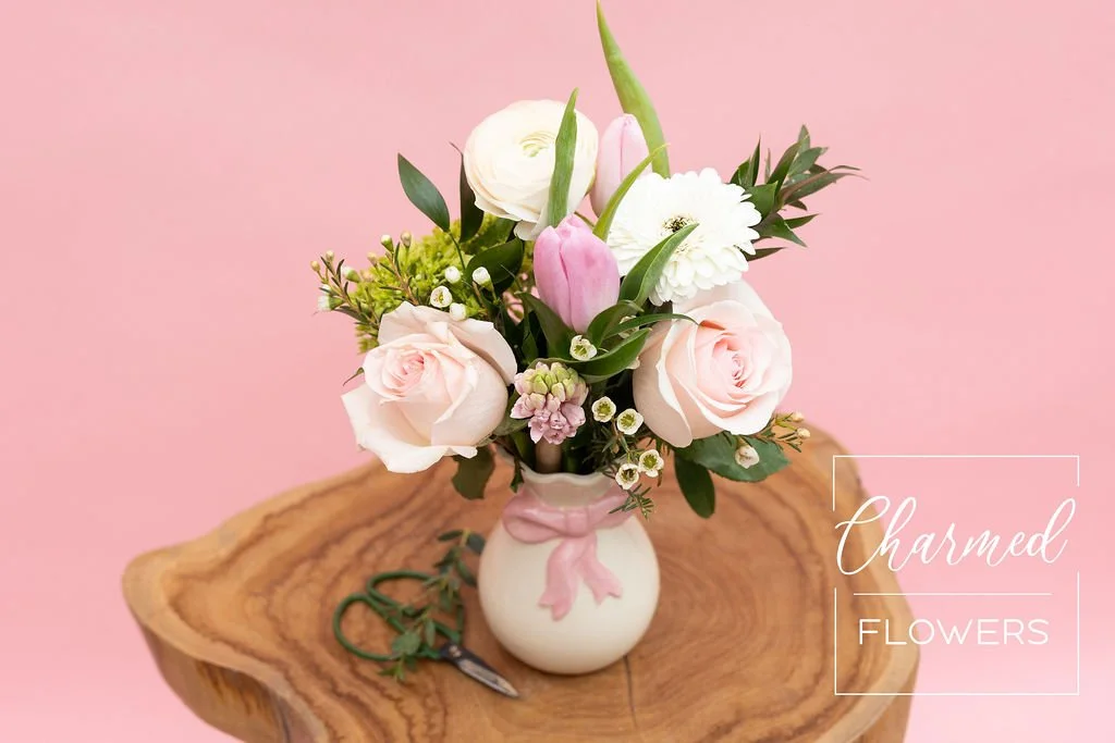 The Sweethearts arrangment eclusive to the this bundle is in a feminine vase with a pink bow.