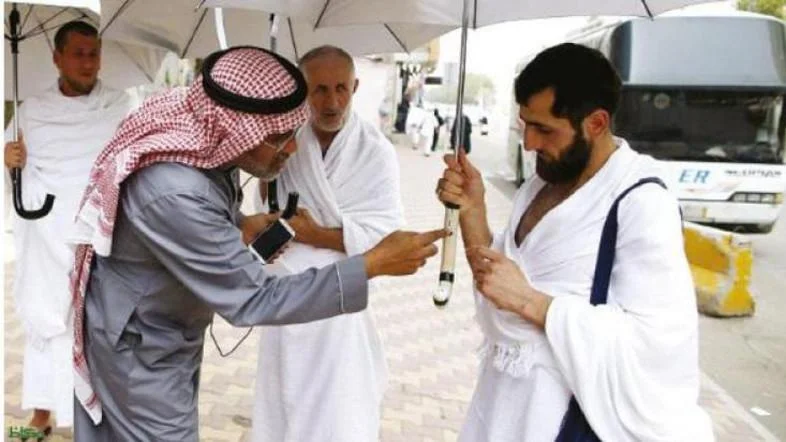 Kamal Badawi, a Saudi engineer from Makkah, explains the features of a smart umbrella to a pilgrims. (Source: Al Arabiya)