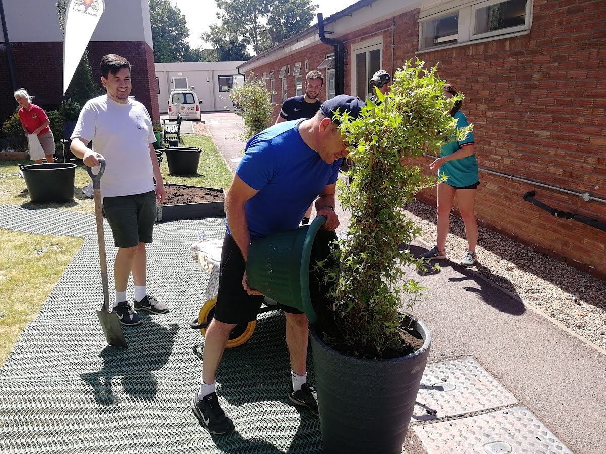 volunteers potting up an ivy plant.jpg