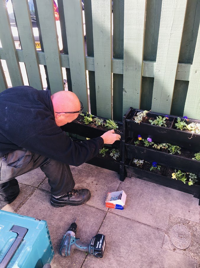 corporate volunteer installing Plant Box living wall planters.JPG