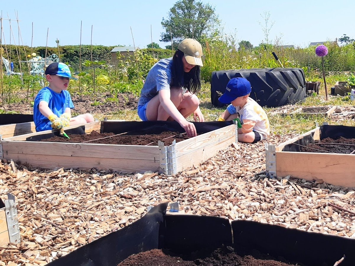 family sowing veg seeds at Meon Vale allotment.jpg