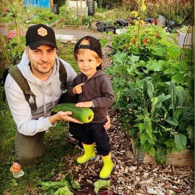 Dad and son at meon vale allotment with courgette.JPG