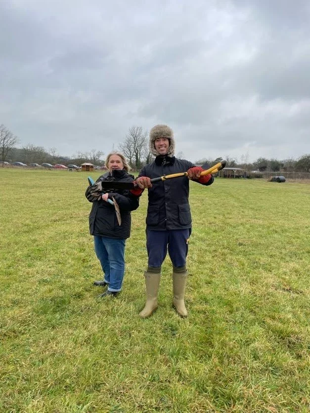 volunteers in grassy field ready to plant trees.jpg