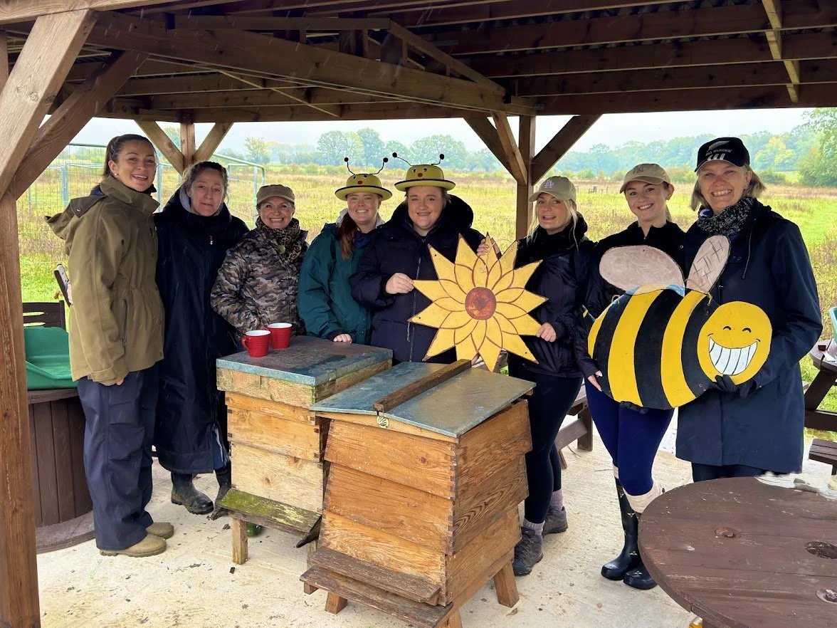 A group of corporate volunteers from Valpak and Reconomy at The Garden of Arden Stratford-upon-Avon during a bee‑themed conservation day, supporting beehive renovation, team building and the Forest of Hearts beekeeping project.