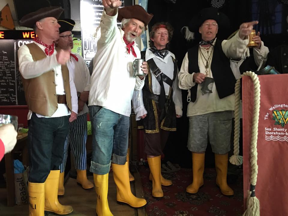 Last Sunday found "The Wellington Wailers", Shoreham's Sea Shanty crew, performing at "The Duke of Wellington". The pub owners Rob & Jess Jones kindly invited the Wailers to host a fund raising afternoon for the Shoreham Lifeboat , whilst also promoting the launch of the Wailers long awaited C.D. "High Tides & Low Life. The C.D. is a recording of twenty seven of the Wailer's most popular sea shanties, retailedat £10 each, with £5 of each sale going to the Lifeboat. The day proved to be a roaring success starting with a light hearted history of sea shanties being delivered to a packed pub. The talk was interspersed with the Wailers singing snatches of sea shanties. Then it was into the pub's garden; which had been lavishly decorated with RNLI flags and bunting, for a treasure hunt and other children'sgames. For anyone with an appetite the lifeboat crew had swapped their oilskins for aprons and ran a barbecue serving tradition meat dishes and delicious freshly caught fish. As if that wasn't enough the Wailers went back on stage, for another performance of sea shanties. This time dressed as pirates, but also sporting RNLI wellies. T hey were followed by a fantastic trio "Bagge, Armer and Piggot playing their Americana folk/Rock music long into the evening. The day was an outstanding success raising approximately £250 for the Lifeboat. Huge thanks must be given to Rob and Jess Jones, for not only sponsoring the event, but also as being the official sponsors of The Wellington Wailers. This coming weekend the Wailers will be performing for the fourth time at "The International Sea Shanty Festival" in Falmouth and we hope to confirm Rob and Jess's confidence in us.