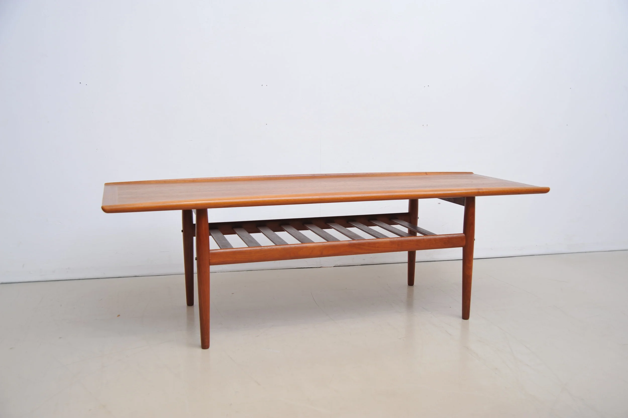grete-jalk-couchtisch-tisch-coffee-table-teak-braun-rand-surfboard-zeitungsablage-ganz.JPG
