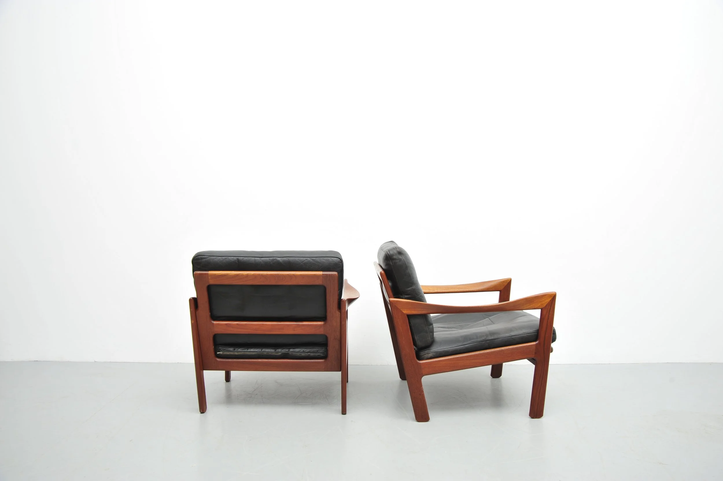  Easy Chair 1950iger    Die Sessel sind aus massiven Teakholz gefertigt und haben lose aufliegende Kissen die mit schwarzem Leder bezogen sind.    Hersteller: Niels Eilersen, Dänemark  Desigen: Illum Wikkelsøe, 1919-1999 Dänemark    Sehr guter Zustan