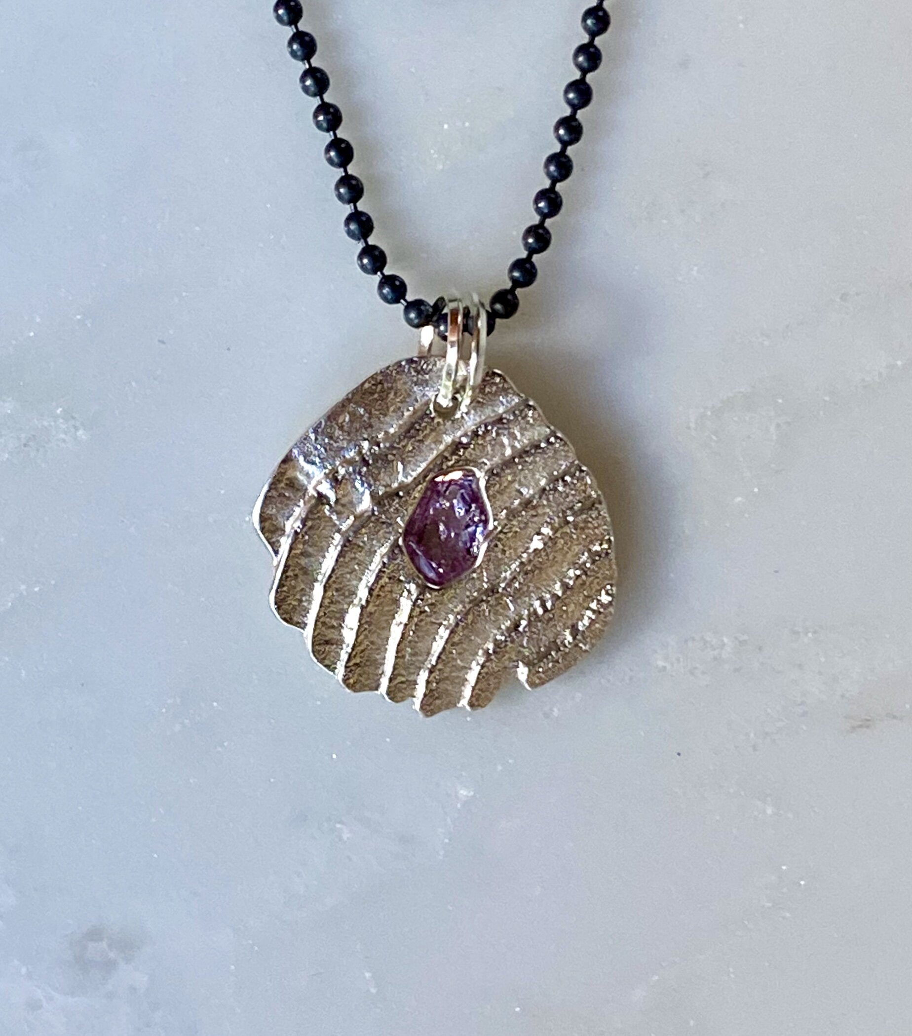 Small sterling silver cuttlefish cast pendant with pink spinel