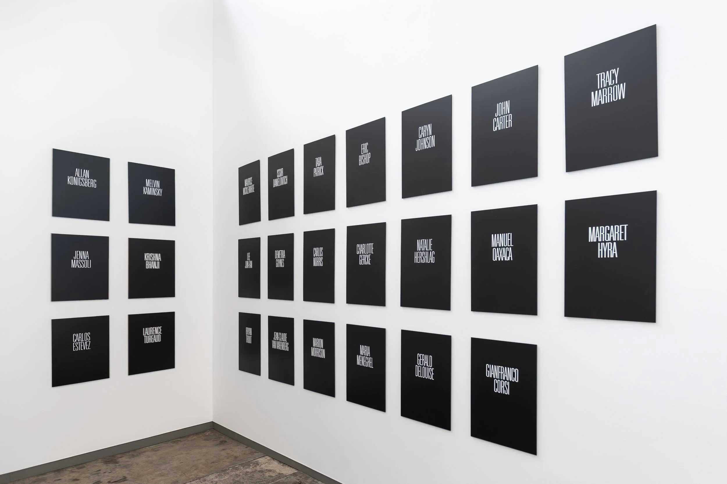 Text-based art installation of the Legends series at NordArt, featuring large-scale black-and-white title cards of iconic musicians and actors hung in linear order within the historic industrial architecture of the Carlshütte exhibition hall.