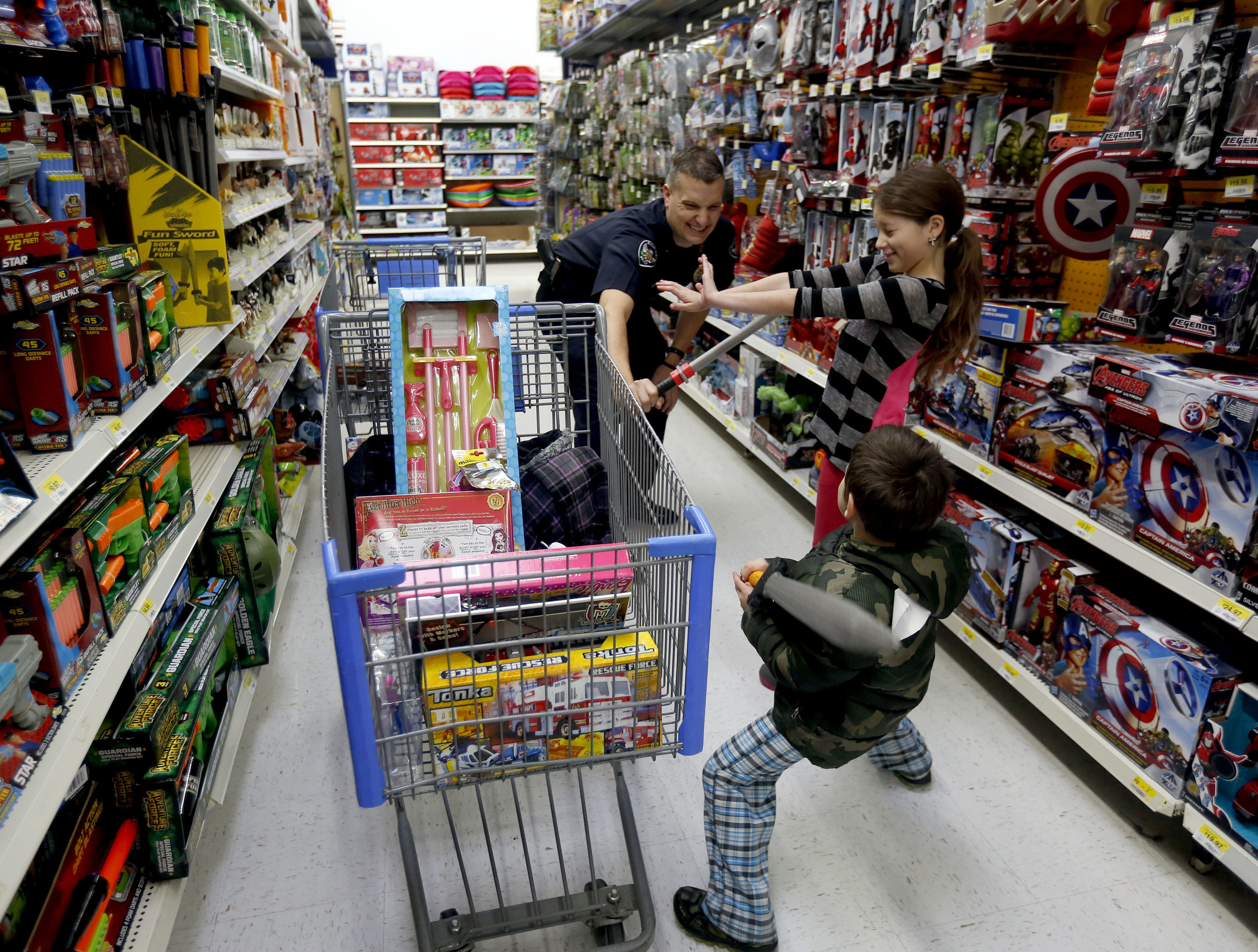  Audrea Martinez, right, 9 of Richland, tries to break up a play toy fight between her brother Roman Canon, 5, and Richland Police Department Officer Eric Edwards Saturday December 12, 2015 during the Shop with a Cop event at the Richland Wal-Mart. M