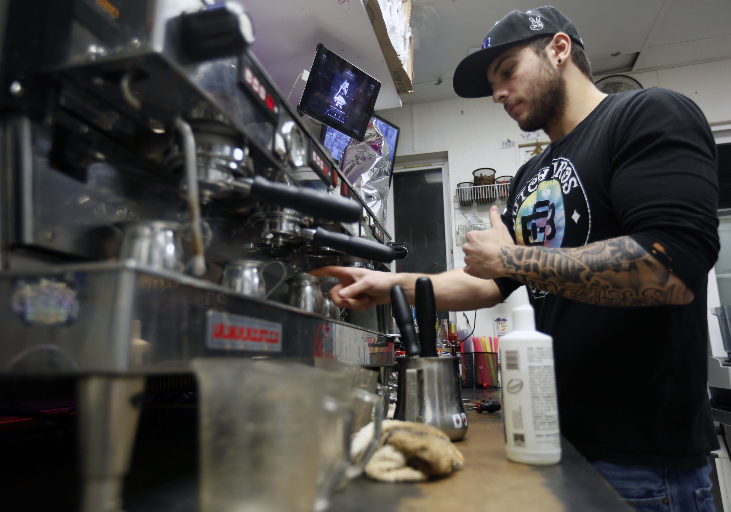   Zade Hakki cleans the espresso machine while working at 12 a.m. on the graveyard shift at Dutch Bros. Coffee on Clearwater Avenue in Kennewick. For Hakki the job isn’t about making coffee but the conversations with customers.     