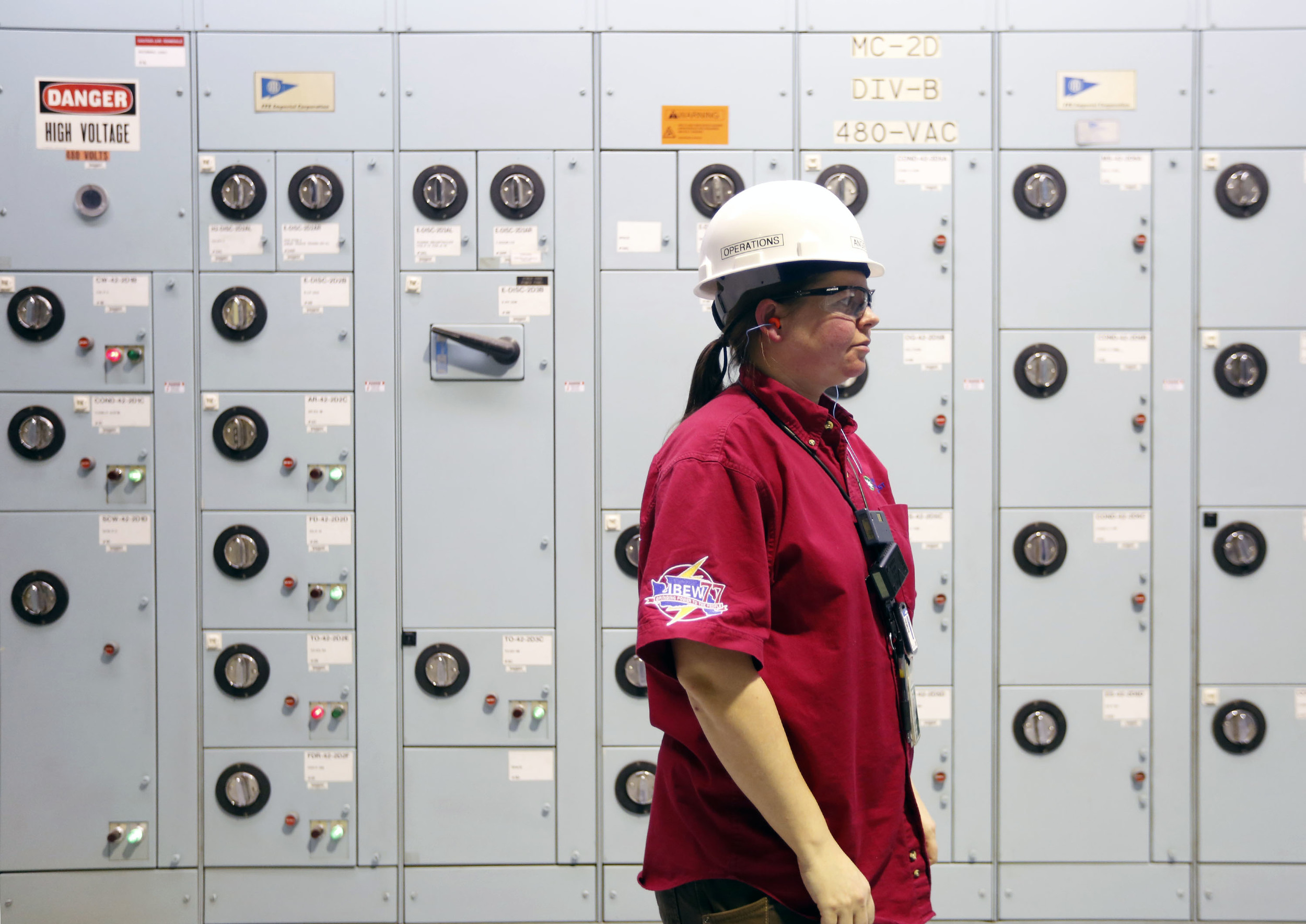   Angela Deahl, an equipment operator, stands in front of a wall of equipment during her overnight shift at the Columbia Generating Station near Richland. Deahl, who started her career in the Navy, is one of two women on a team of 39 equipment operat