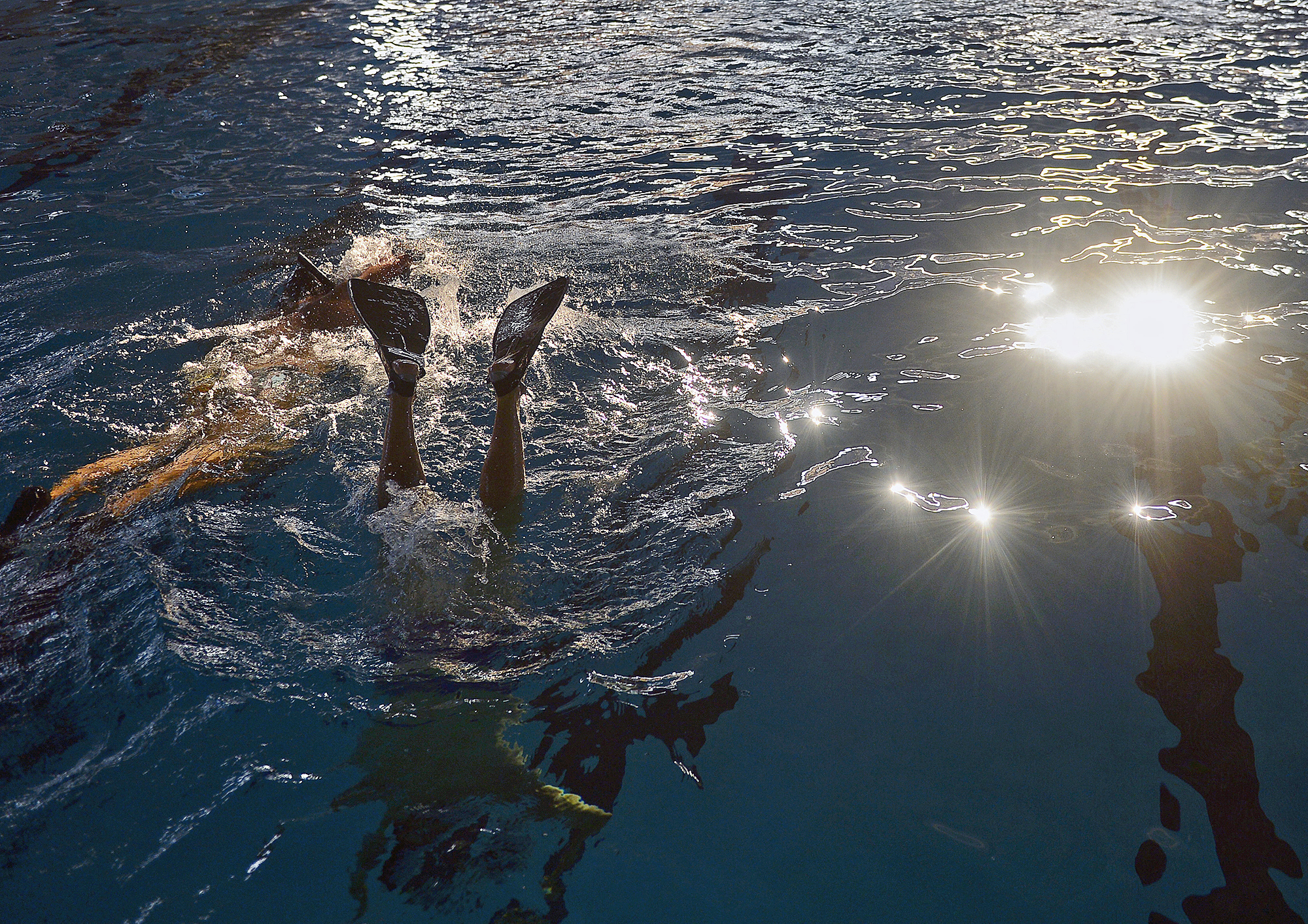  Swimmers move past sunlight reflected on the water during a pickup game with Southeast Connecticut Underwater Hockey on Sunday, August 26, 2018 at UConn Avery Point. 