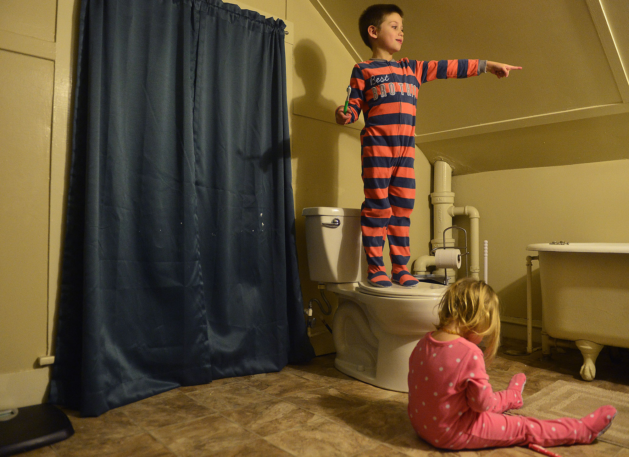 Colton stands on the toilet to brush his teeth while Hadley sits on the floor and tries to get toothpaste out of the tube as they get ready for bed on Thursday, Jan. 18 at their home in Groton. "I'm ready for this to be a two parent household again,