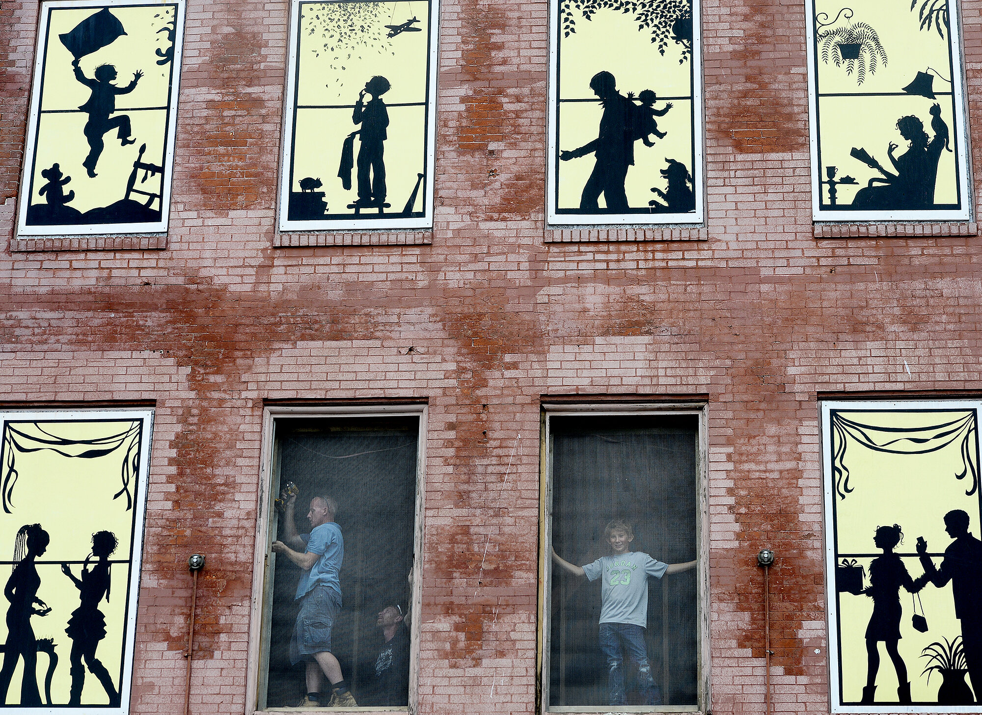  Workers with DC Construction Barry Huntoon, left, and Vince Haggett, center, work on a window frame of the Metropolitan Hotel building as Ben Ceccarelli, 12 years old, looks out a window at Bank Street on Tuesday, August 15, 2017, in New London. The