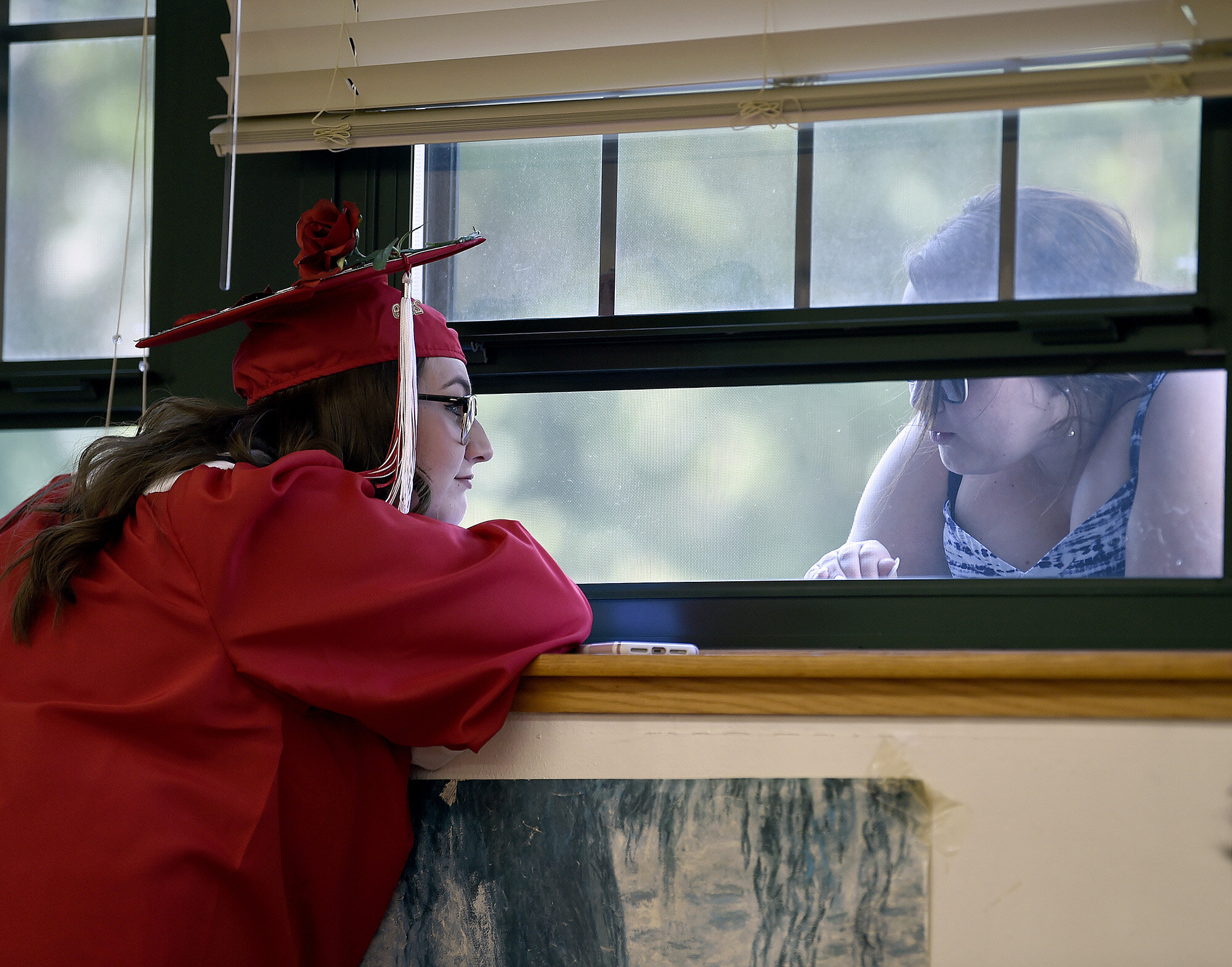  Graduate Abby Bargnesi, left, talks to her sister Taylor through a window before Norwich Free Academy's Commencement Ceremony on Wednesday, June 12, 2019. (The Day)  