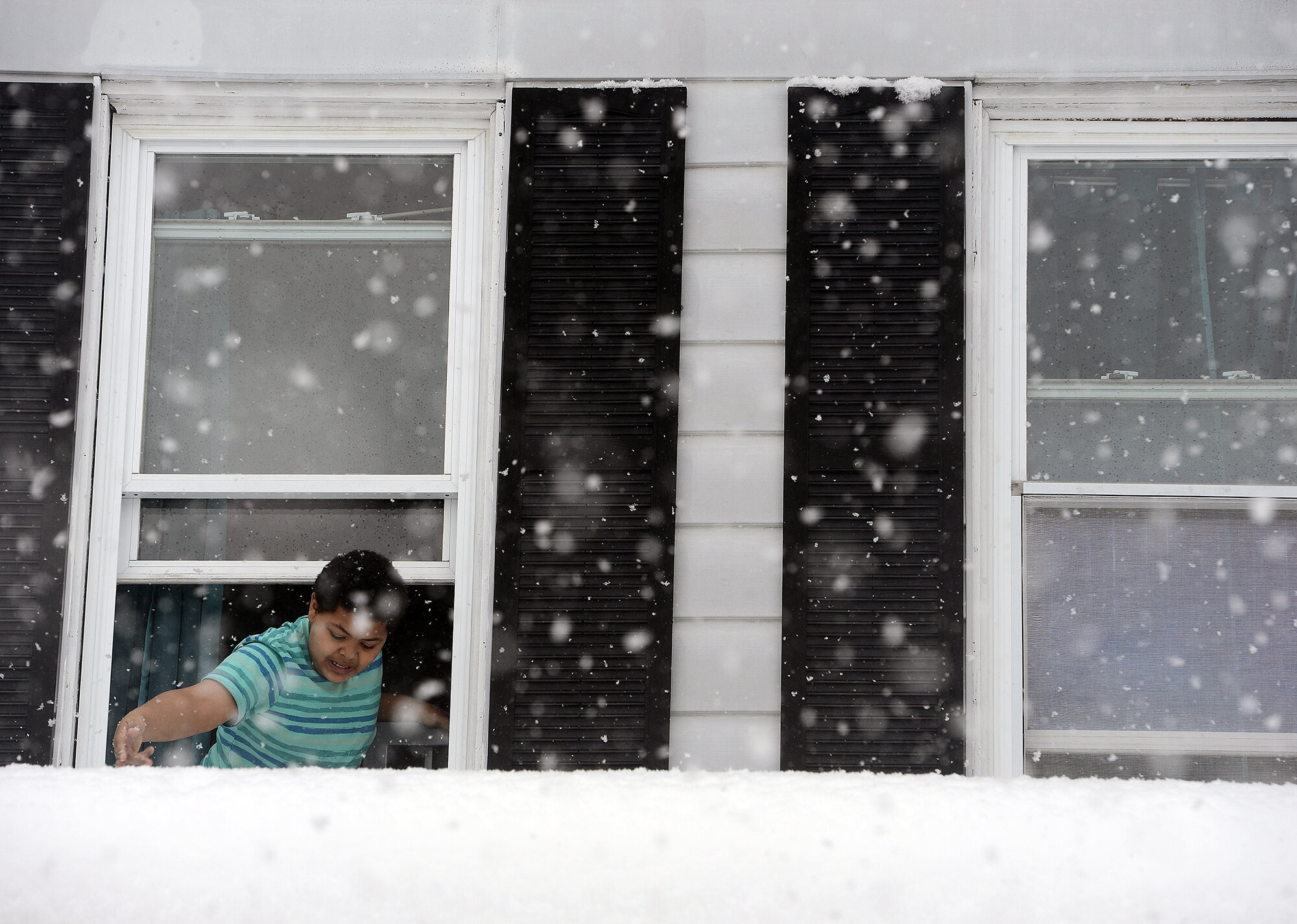  Paulie Perez Hughes, 10 of New London, uses his fingers to check how much snow has accumulated on the roof as he leans out the window during the snowstorm on Tuesday, March 13, 2018 at his cousin's home on West Coit Street in New London. "I think I 