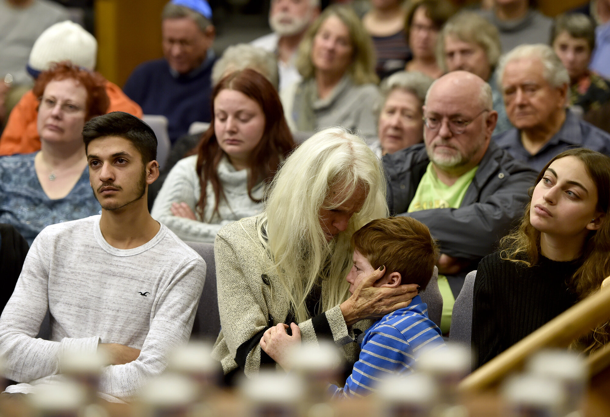  Liz Bochain holds her son Jacob Feinsteil, 9, as they react to a speaker during a “Prayers for Pittsburgh” vigil at Temple Emanu-El on Monday, October 29, 2018 in Waterford. (The Day)  