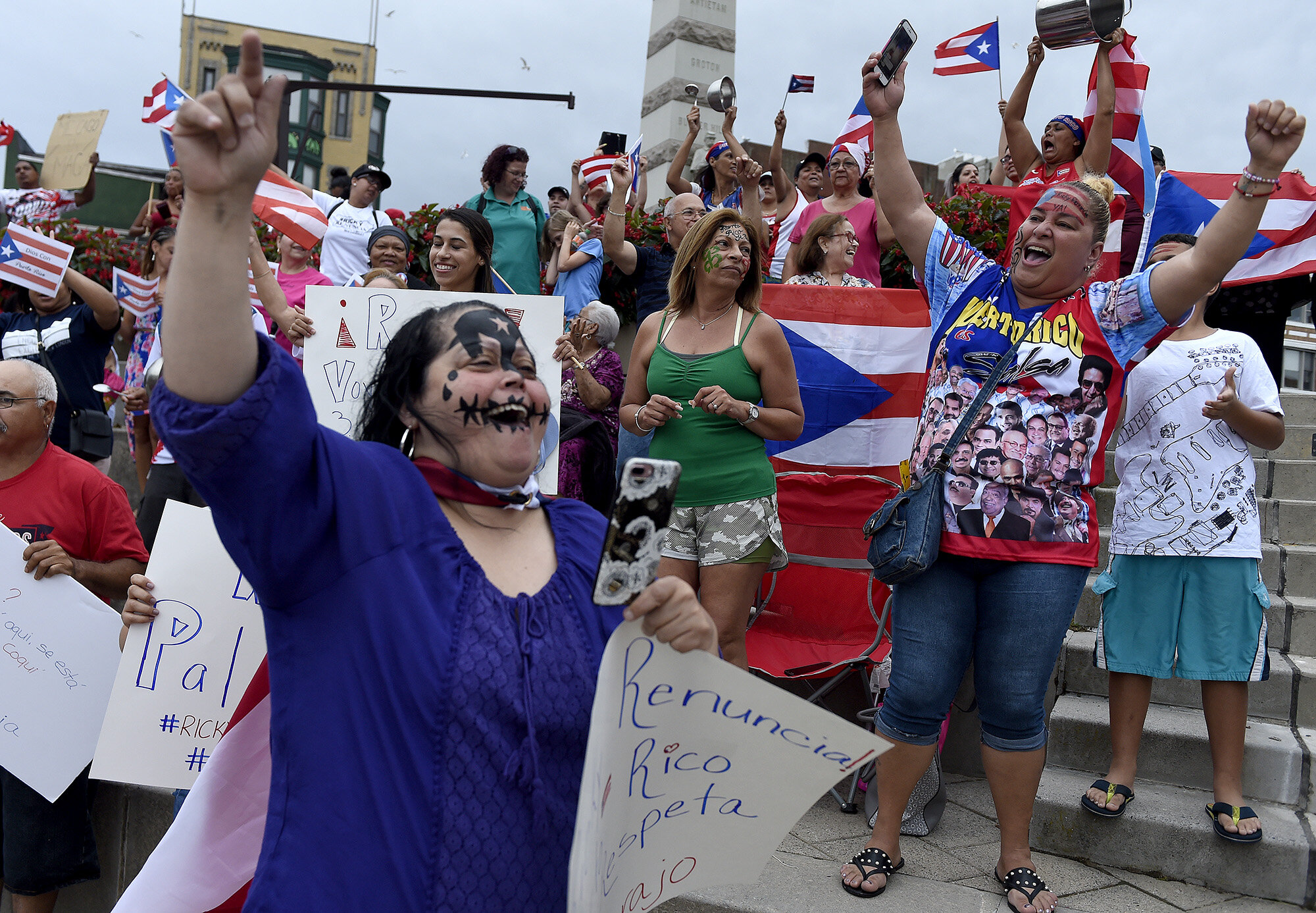  Anna Agosto, right, of New London, and other members of the crowd sing along to a song during a rally in support of Puerto Rico on Monday, July 22, 2019 at the Whale Tail in New London. The local event was part of sweeping protests across the countr