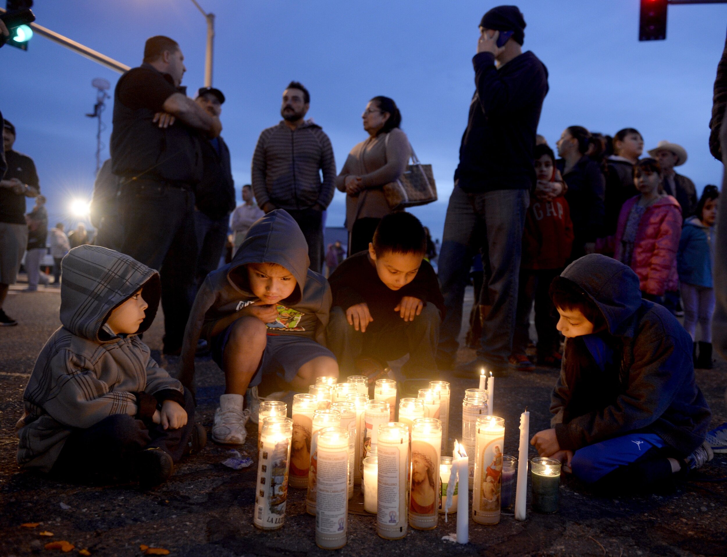  Pasco residents, from left, Angel Morgan, 5, and his brother Jose Morgan, 6, as well as Alex Gonzalez, 4, and his brother Angel Gonzalez, 8, gather around a candlelit vigil Wednesday evening at the intersection of 10th Avenue and Lewis Street in Pas