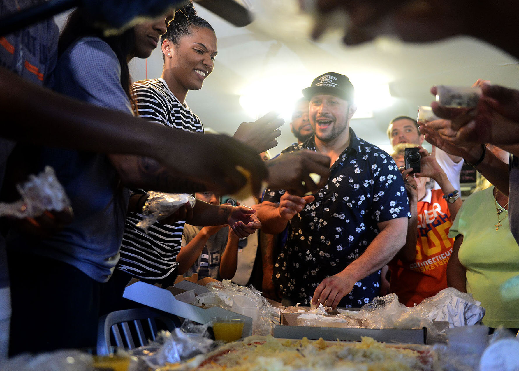  Crown Pizza owner Taso Vitsas, center, looks on Connecticut Sun player Alyssa Thomas as she helps put cheese on a pizza as they attempt to break the world record for most types of cheese on a pizza on Thursday, August 10, 2017, at restaurant in Wate