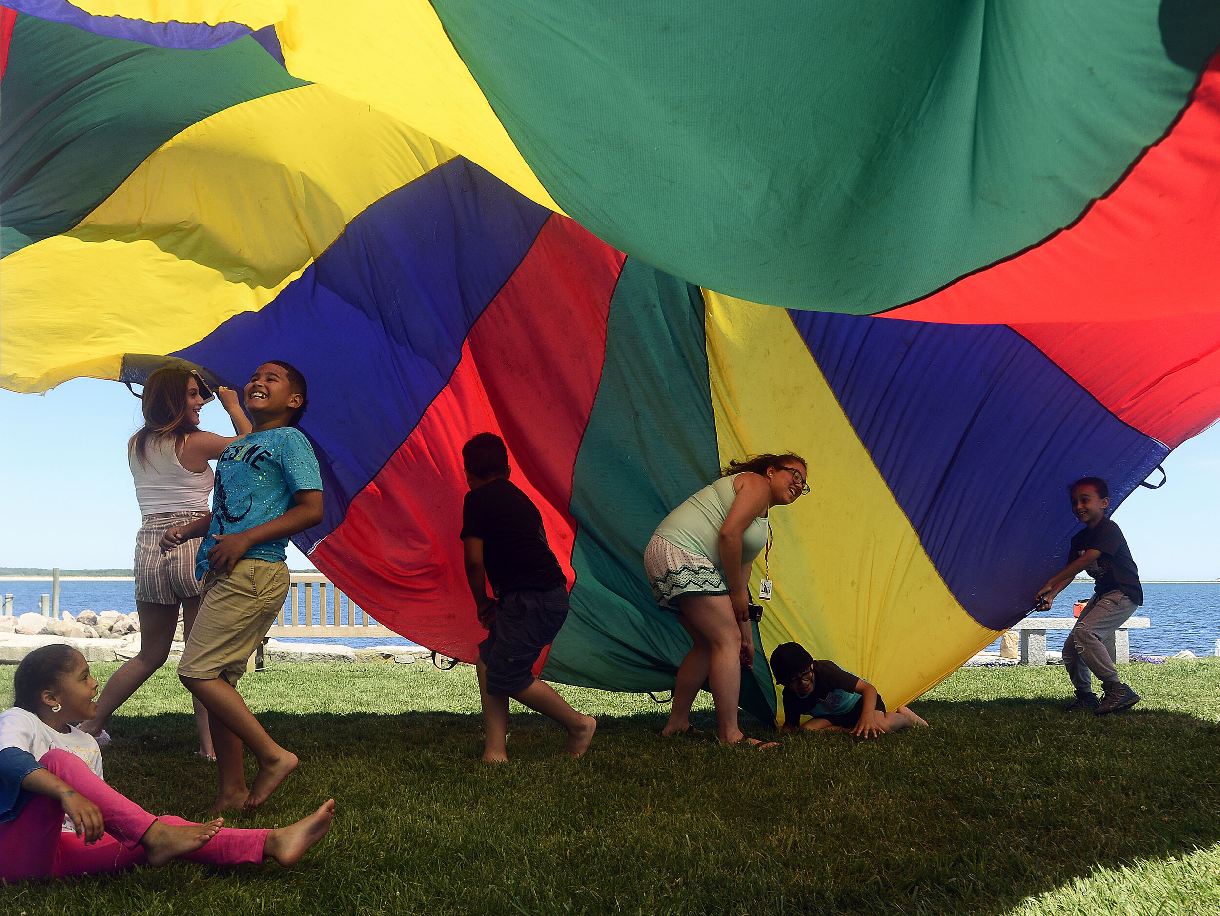  Students with the Windham Heights Learning Center, in Wilimantic, run underneath a parachute as they play at Stonington Point on Tuesday, June 26, 2018 while on a field trip. (The Day)  