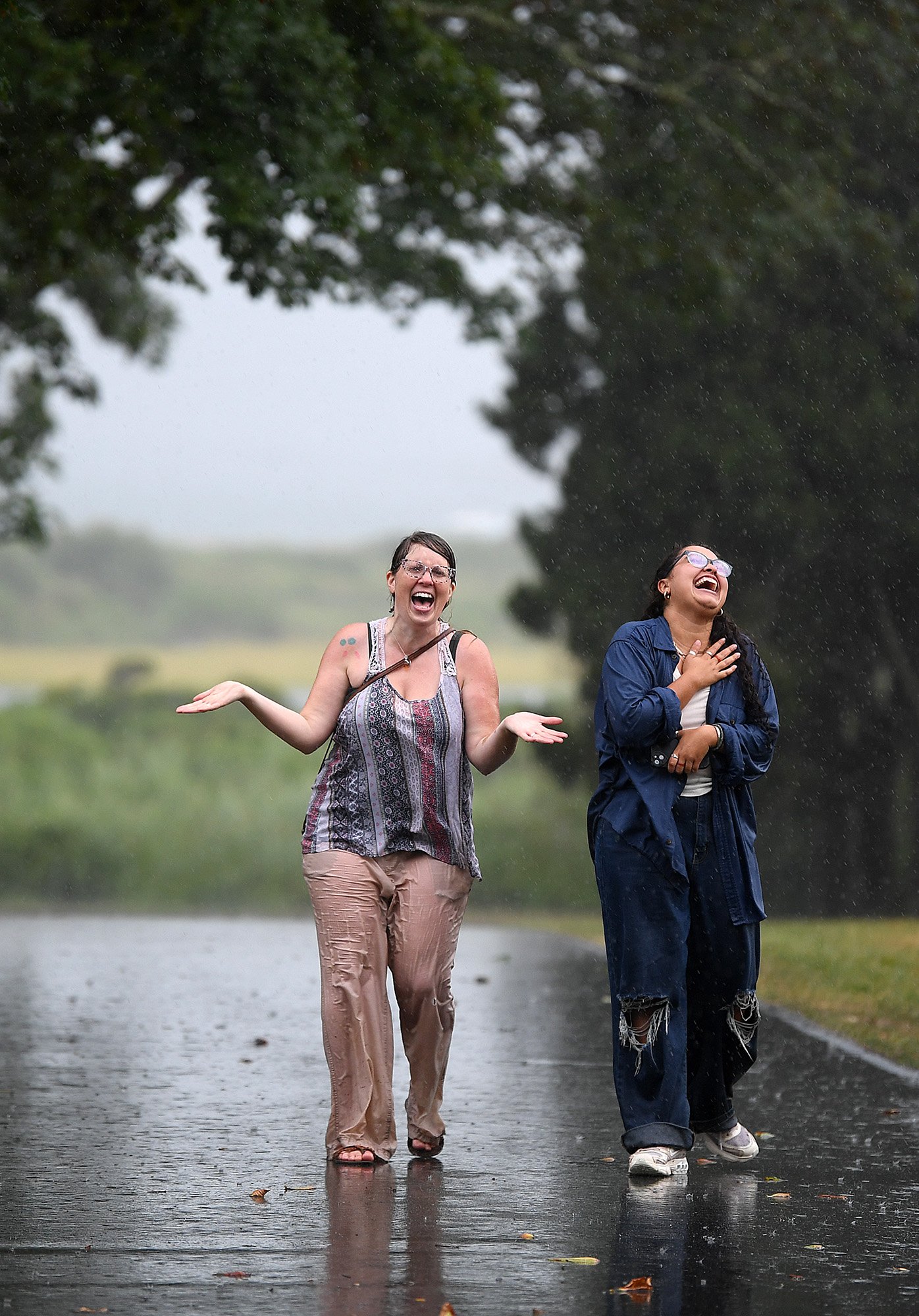  Friends Ashley Thompson, left, and Anya Duarte of Montville, walk through Harkness Memorial State Park in Waterford as it rains Wednesday, August 17, 2022.  “We both needed a walk with a friend in a pretty place to relieve some stress,” said Duarte.